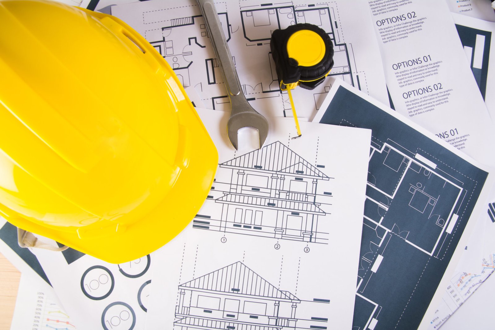 engineer workplace with blueprints protractor safety helmet scaled |